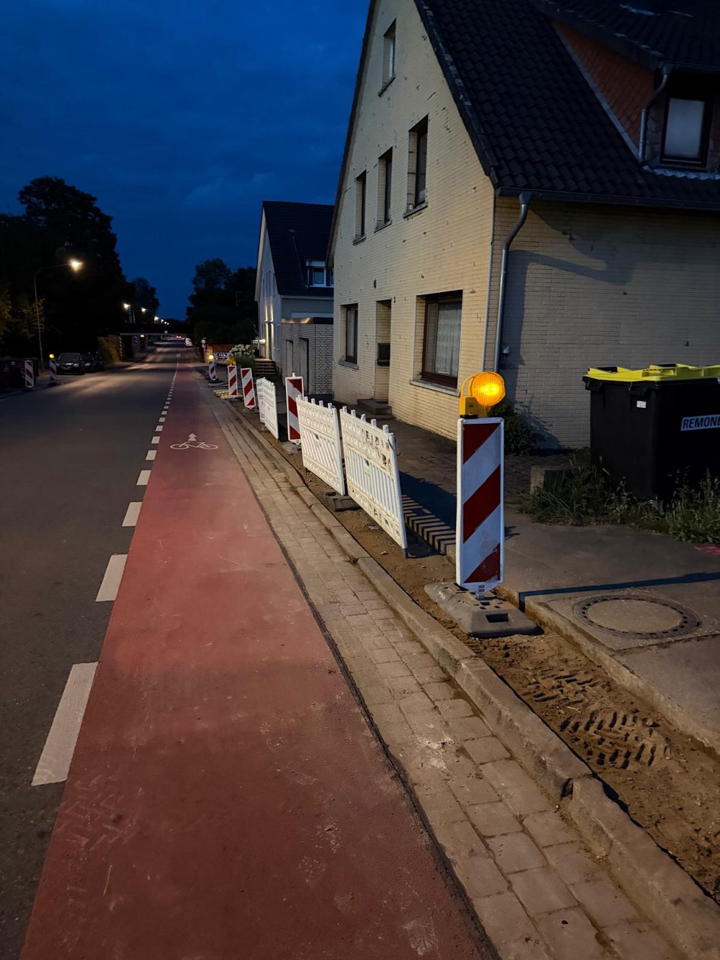 Absicherung der Tiefbauarbeiten auf dem Gehweg vor einem Wohnhaus